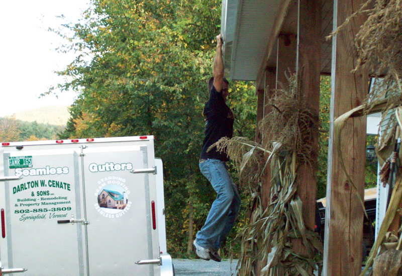 Guy hanging from gutters to show their durability